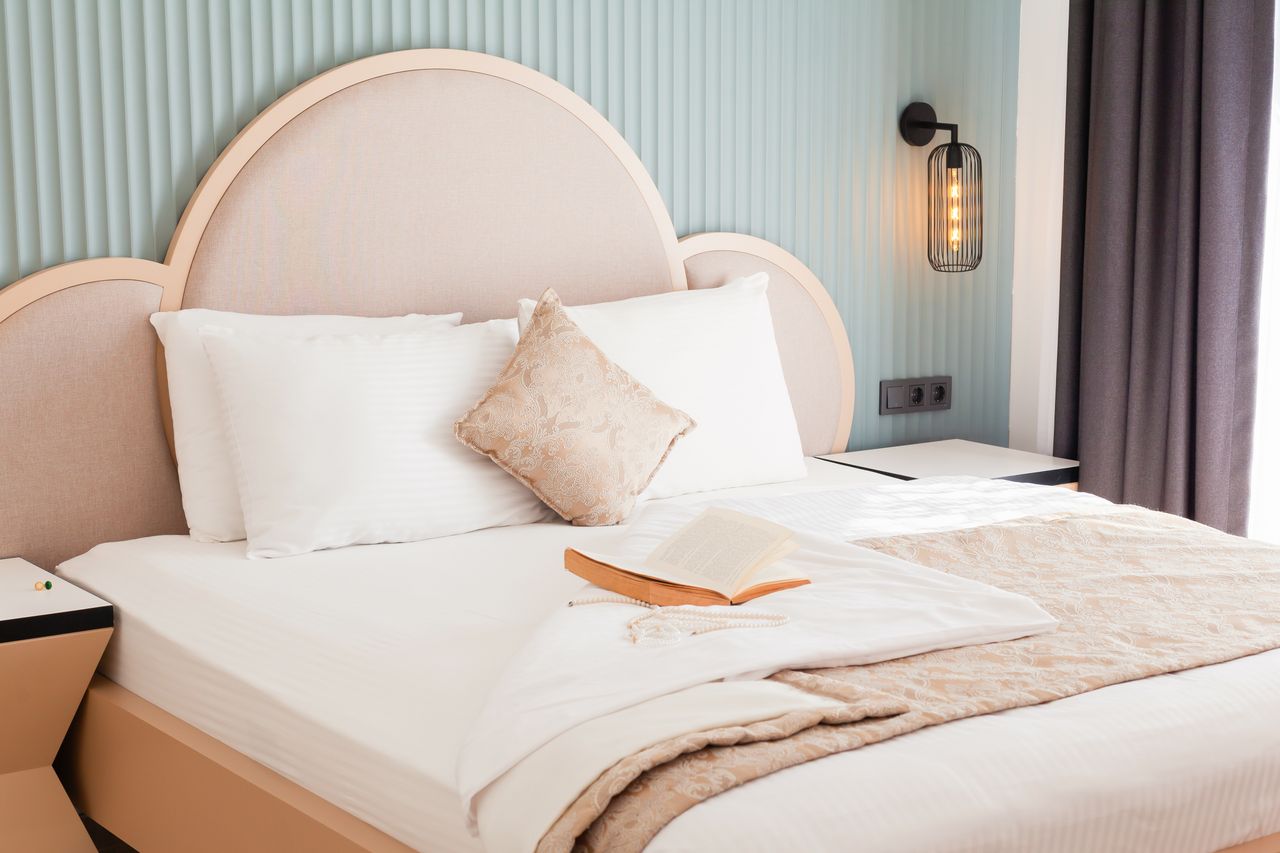 The Art of Drawing Readers In: Your attractive post title goes here A luxurious hotel bedroom featuring elegant bedding and an open book, exuding comfort and style.
