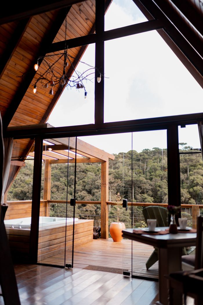 Mastering the First Impression: Your intriguing post title goes here A tranquil cabin interior with large windows and hot tub overlooking a forest.