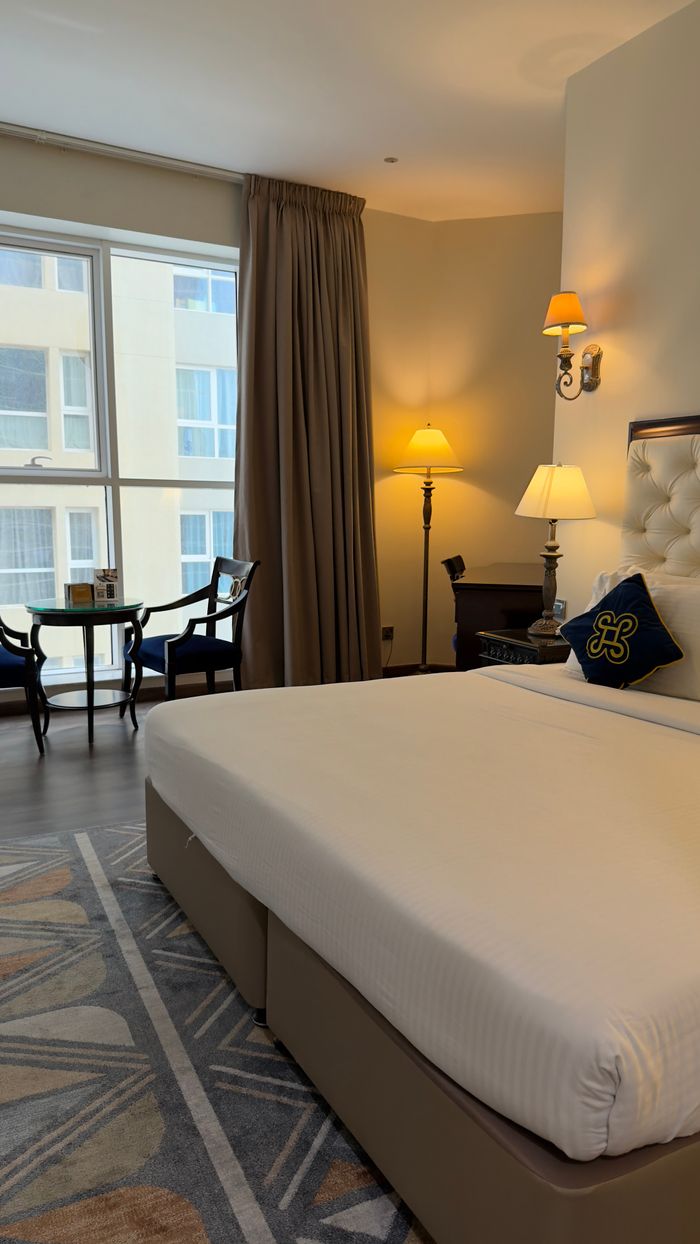 Hello world! A well-appointed hotel room featuring stylish furniture, ambient lighting, and large windows.